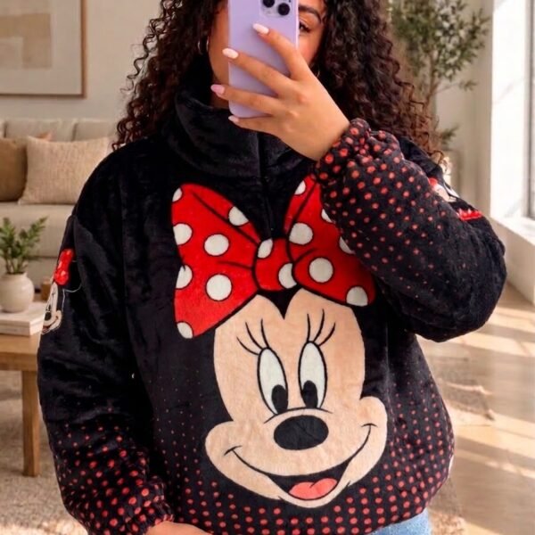 Mujer con saco térmico afelpado negro con la cara de Minnie y moño rojo de puntos