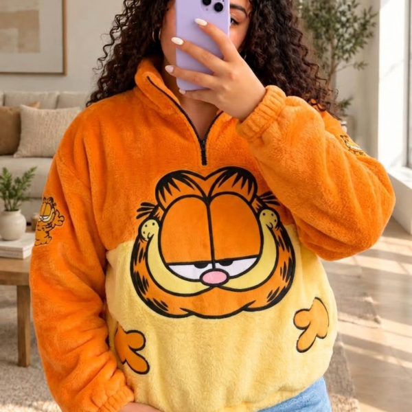Mujer con saco térmico afelpado naranja y amarillo con la cara de Garfield en el frente